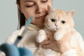 A young girl with a cute cream cat at the vet is preparing to be vaccinated