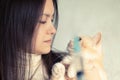 A young girl with a cute cream cat at the vet is preparing to be vaccinated