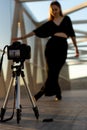 A young girl dancing on a pedestrian bridge and filming herself with a professional camera Royalty Free Stock Photo