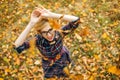 Young girl dancing under falling leaves in the autumn park Royalty Free Stock Photo
