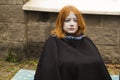 Young girl in Dead costume sits in the park. Halloween concept