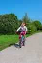 cute little girl riding a bicycle in the countryside in spring