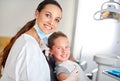 Young girl and dentist with smile in office on chair, appointment or results in consulting room. Professional, child and Royalty Free Stock Photo