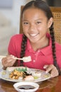 Young girl in dining room eating Chinese food Royalty Free Stock Photo