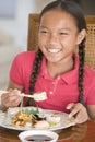 Young girl in dining room eating Chinese food Royalty Free Stock Photo