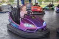 Young girl on dodgem bumper car ride at amusement fair