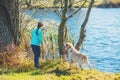 Young girl with dog on the lake shore