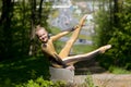 Young girl doing strength gymnastic exercises workout in a beautiful suit outdoors in a park.