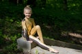 Young girl doing strength gymnastic exercises workout in a beautiful suit outdoors in a park.