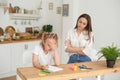 Young girl doing homework during extra-curricular classes with a tutor. Frustrated young mother or tutor teaching kid at Royalty Free Stock Photo