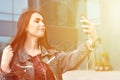 Young girl doing selfie on the background of an office building