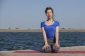 Young girl doing yoga or fitness exercise outdoor in nature with beautiful lake. Meditation and Relax concept Royalty Free Stock Photo