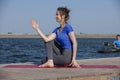 Young girl doing yoga or fitness exercise outdoor in nature with beautiful lake. Meditation and Relax concept Royalty Free Stock Photo