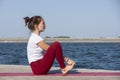 Young girl doing yoga or fitness exercise outdoor in nature with beautiful lake. Meditation and Relax concept Royalty Free Stock Photo