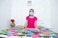 Young girl doing yoga indoor during quarantine, doing meditation during lockdown. Health, exercise stay at home and self-care for Royalty Free Stock Photo