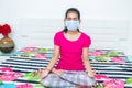 Young girl doing yoga indoor during quarantine, doing meditation during lockdown. Health, exercise stay at home and self-care for Royalty Free Stock Photo