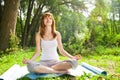 Young girl doing yoga lotus pose in park Royalty Free Stock Photo