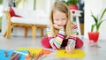 Young girl drawing with colorful pencils at home. Creative kid doing crafts. Education and distance learning for kids. Royalty Free Stock Photo