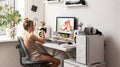 A young girl draws on a PC using a graphics tablet in her comfortable home office. Royalty Free Stock Photo