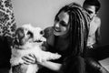 Young girl with dreadlocks holding a dog Royalty Free Stock Photo