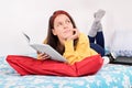 Young girl dream-reading on her bed Royalty Free Stock Photo