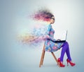 Young girl in dress and glasses sitting on a chair with laptop Royalty Free Stock Photo