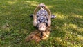 A young girl in a dress lies on the green grass with a phone in her hands. The girl lies on her back in the summer park. Royalty Free Stock Photo