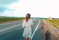 A young girl in dress is walking along the road. Stork in the Far East Royalty Free Stock Photo