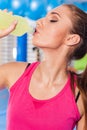 Young girl drinking isotonic drink, gym