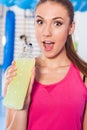 Young girl drinking isotonic drink, gym. She is happy and full o Royalty Free Stock Photo