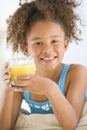 Young girl drinking orange juice in living room Royalty Free Stock Photo