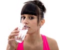 Young girl drinks a glass of water, on white Royalty Free Stock Photo