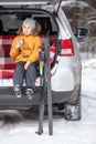 Young girl drinks hot tea after skiing while sitting in trunk of suv car. Winter activity Royalty Free Stock Photo