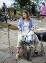 Young girl drummer playing drum alone in a city park. Girls Bike Parade