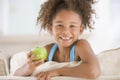 Young girl eating apple in living room smiling Royalty Free Stock Photo