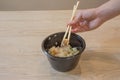 Young girl eating in a Chinese food, they eating with chopsticks, close-up on hands and food Royalty Free Stock Photo