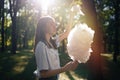 Young girl eating cotton candy at park Royalty Free Stock Photo