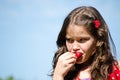 Young girl eating a fresh strawberry