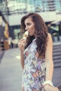 Young girl eating ice cream in the city street Royalty Free Stock Photo