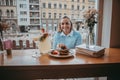 Young girl eating pancakes and drink coffee