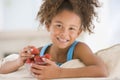 Young girl eating strawberries in living room Royalty Free Stock Photo