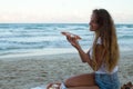 The young girl eats pizza on the beach, a dinner on the beach.