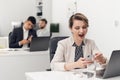 A young girl employee of a Bank or insurance company is bored and yawns at the workplace. office routine Royalty Free Stock Photo