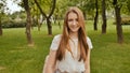 A young girl is engaged in a walk in the park, looking at a smart clock on her arm and receiving a pulse measurement Royalty Free Stock Photo