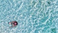 Young girl enjoying a beautiful beach shoreline. Crystal clear ocean water, downward view from drone