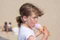 Pretty little girl enjoying her ice cream cone on the beach