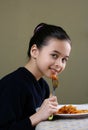 A young girl enjoying her ribbon pasta