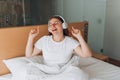 Young girl enjoying music with wireless headphones, she relaxing in cozy bedroom at home. Enjoy good quality sound Royalty Free Stock Photo