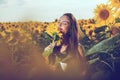 Young girl enjoying nature on the field of sunflowers. Portrait of the beautiful girl with a sunflowers. Royalty Free Stock Photo