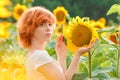 young girl enjoying nature on the field of sunflowers at sunset, portrait of the beautiful redheaded woman girl with a sunflowers Royalty Free Stock Photo